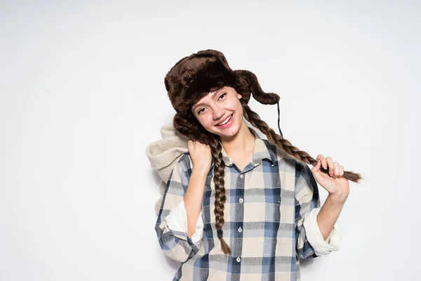 Sonriente chica rusa en un sombrero de piel con coletas sosteniendo cálidas botas de invierno — Foto de Stock