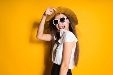 Kız şapka ve güneş gözlüğü arka plan üzerinde poz