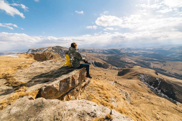 Chica se sienta en un acantilado, viaja y disfruta —  Fotos de Stock