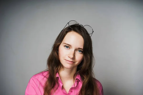 Confiante bela jovem mulher na camisa rosa pensa sobre o trabalho, sorrindo — Fotografia de Stock