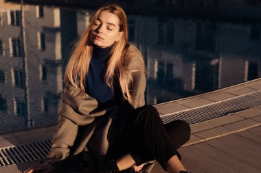 bahar güneş ışınlarının gözleri kapalı havuzda tarafından dinlenme güzel genç sarışın model kız