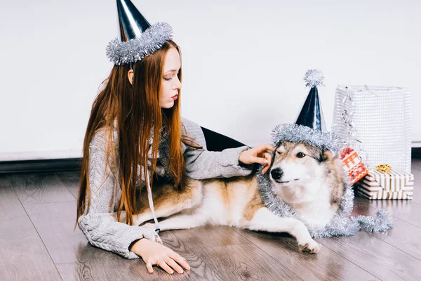 美丽的红头发女孩躺在地板上, 她的大狗庆祝新年 — 图库照片