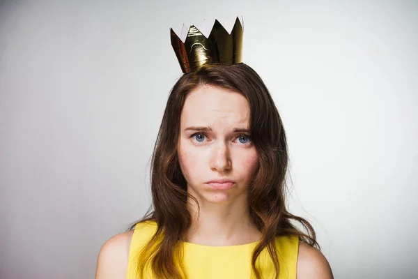 Dulce chica triste en un vestido amarillo está molesto, en su cabeza una corona de oro no recibió un regalo — Foto de Stock