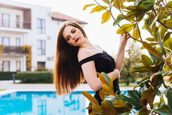 En lyxig ung kvinna med långt hår går runt sin trädgård, utgör, har avkopplande — Stockfoto