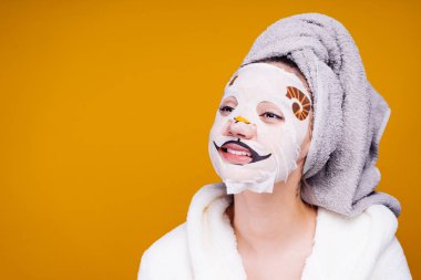 genç kız, yüz maskesi köpek yüzlü üzerinde gülümseyen başında bir havlu ile