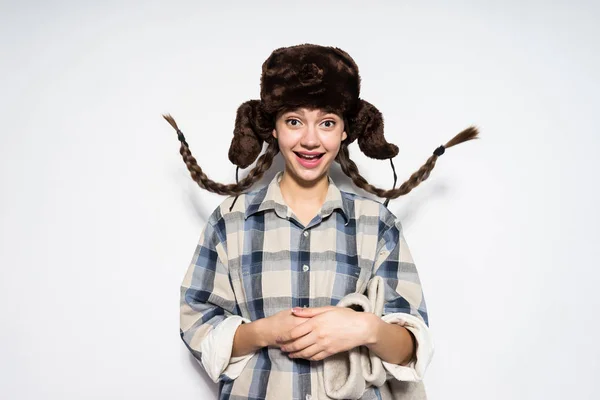 Happy Russian girl in fur hat with pigtails smiling, holding felt boots — Stock Photo, Image