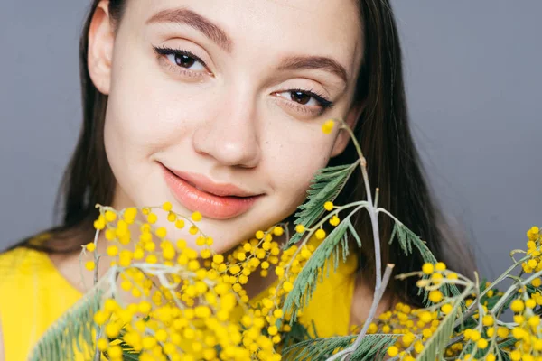 sevimli genç kız gülümseyerek, sarı Mimoza büyük bir buket holding