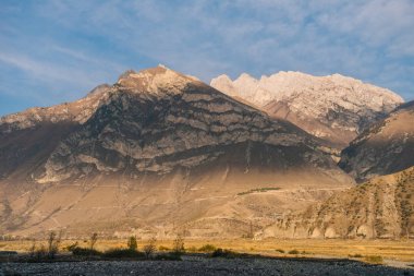 Sihirli doğa, güneşin altında mavi gökyüzü görkemli yüksek dağlar