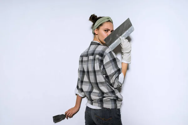 Giovane ragazza in una camicia a quadri linee e colori le pareti nel suo nuovo appartamento, riparazioni — Foto Stock