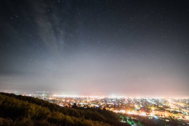küçük bir şehir, ışıklar ve ışıklar gece gökyüzü altında yukarıdan bir görünüm