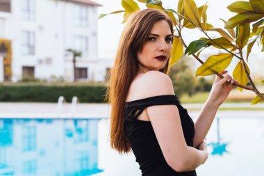 diğer çekici uzun saçlı kadının bahçesine doğru yürüyen siyah elbise