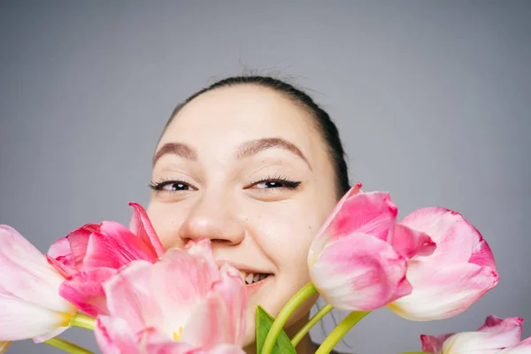Mujer sonriendo y riendo, sosteniendo flores — Foto de Stock