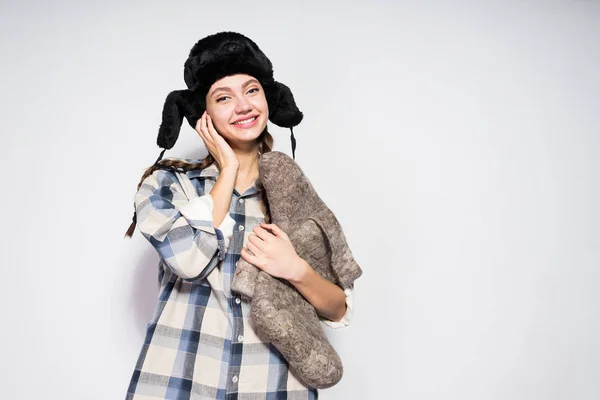 Chica en sombrero de piel esperando el invierno, la celebración de botas —  Fotos de Stock