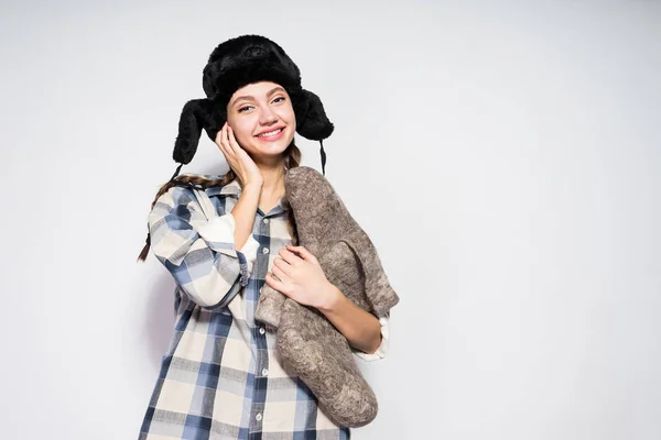 Mädchen mit Pelzmütze wartet auf den Winter, hält Stiefel in der Hand — Stockfoto