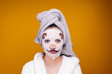 sevimli genç kız başında, onun yüz maskesi resmi olan bir hayvan üzerinde bir havlu ile