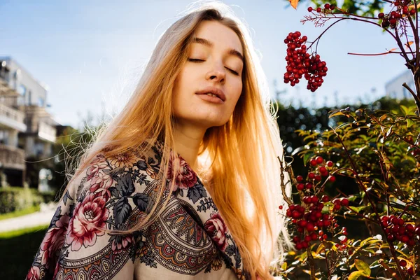 Chica rubia pasea por el jardín, disfruta de la naturaleza y el clima cálido de primavera, cerró los ojos — Foto de Stock