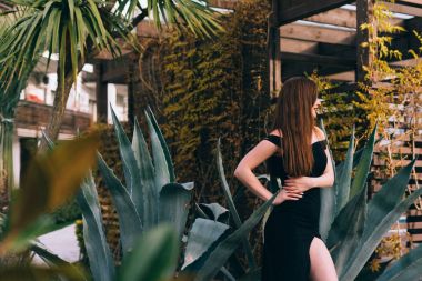 dinlenme ve rahatlama zevk çekici genç kadın onu bahçede poz siyah elbise