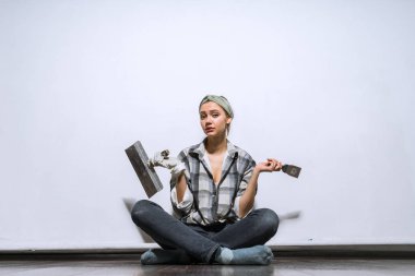 sevimli genç kız onun evinde katta oturur, spatula onarım onun elinde tutan