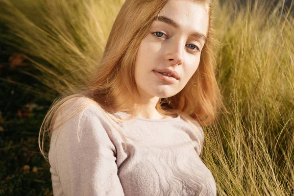 Krásný modrooký děvče blond model představuje venku na slunci — Stock fotografie