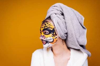 genç kız gülümsüyor, yüzünde bir maske bir namlu bir hayvan ile başında bir havlu ile