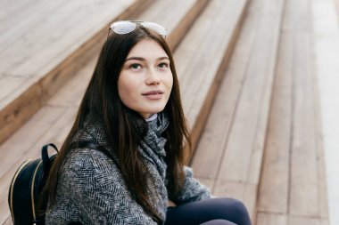 adımları açık havada oturup koyu saçlı sevimli genç kız