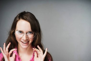 mutlu genç kadın memur pembe gömlek ve gülümseyen ve kameraya bakarak gözlük