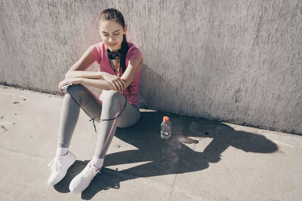 Slim atletisk ung flicka vilar efter gatan träningspass, envist engagerade i sport — Stockfoto