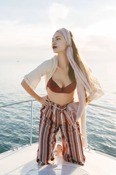 An attractive luxury girl rests on her big yacht, enjoys a vacation and the sun — Stock Photo, Image