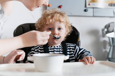 genç güzel annem onun çocuk, evlat, yulaf lapası bir kaşıkla besleme