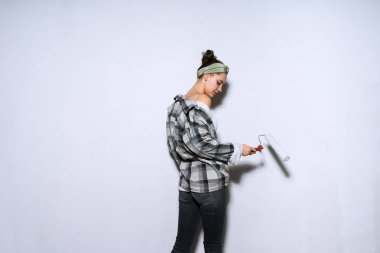 onun evinde onarım yapıyor ve bir panel beyaz kullanarak duvarları boyama ekose gömlekli genç kız