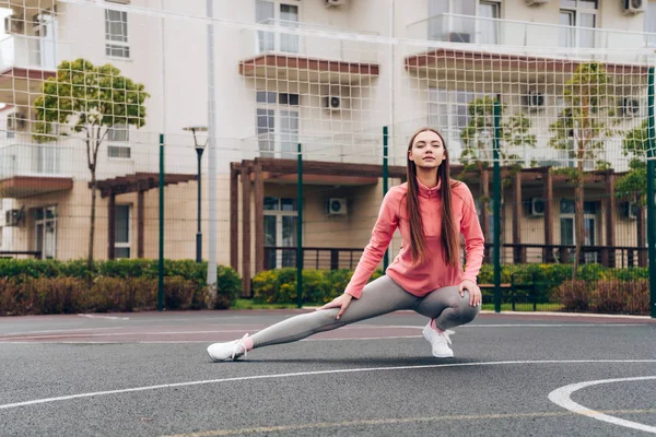 Jong meisje leidt een actieve en gezonde levensstijl, straat training en het uitrekken — Stockfoto