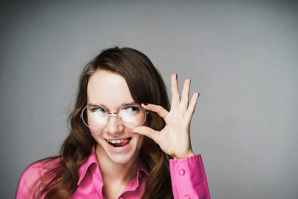 Trabalhador de escritório feliz jovem mulher em uma camisa rosa e óculos sorrindo — Fotografia de Stock