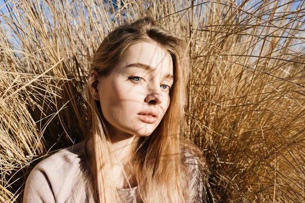 Bela jovem loira menina senta-se ao sol, posando ao ar livre — Fotografia de Stock