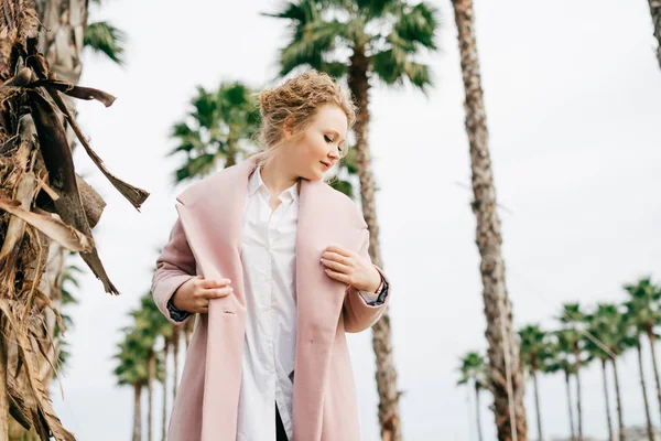 Piękne stylowe młodych kobiet w płaszcz różowy spaceru w parku i cieszyć się ciepłą wiosenna pogoda — Zdjęcie stockowe