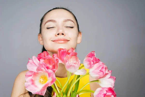 Счастливая молодая девушка с большим букетом душистых цветов, наслаждаясь весной — стоковое фото