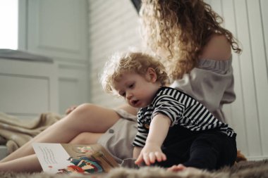 samimi bir aile birlikte, zaman harcamak genç bir anne ve küçük bir çocuk oyun, yere oturur