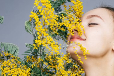 güzel güzel kız güzel kokulu sarı Mimoza ve gülümsüyor, Bahar hava burnunu çekmek