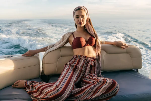 Una chica elegante de lujo disfruta de una vida rica y el ocio en su yate blanco, viaja por mar — Foto de Stock