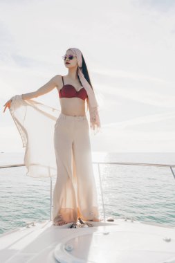 onun beyaz yatta ayakta ve Karayip Denizi, tatil yelken lüks şık genç kadın