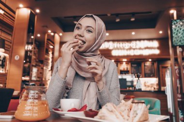 lezzetli yemek yeme bir kafede bir başörtüsü başında güzel Arap kızla akşam