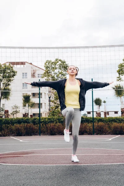Actieve ijverig meisje warmes omhoog en buiten traint op een sportveld — Stockfoto