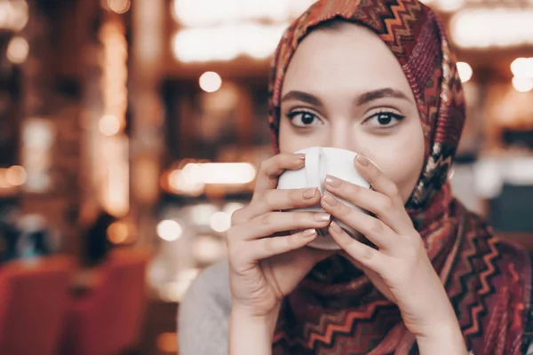 Szép szép Arab lány egy zsebkendőt n agolovo italok illatos kávét a café — Stock Fotó