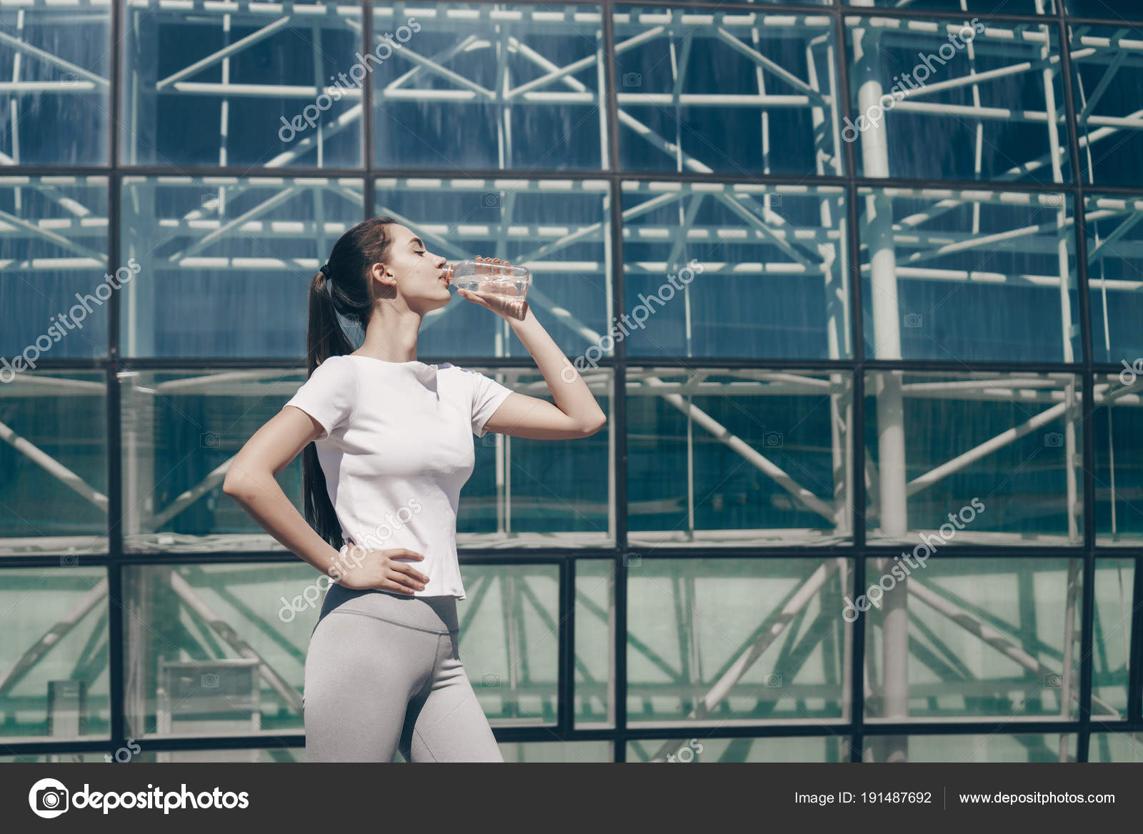 Active young girl eagerly drinks clean water after street training
