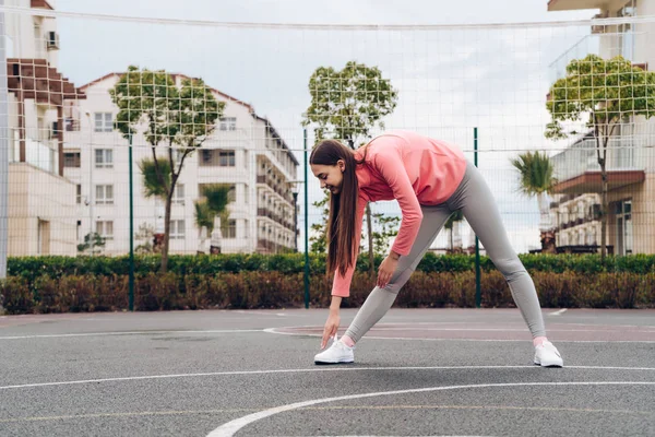Aktiv ung flicka sträcker och knådar muskler innan gatan träning, älskar sport — Stockfoto