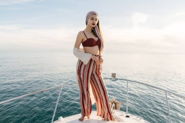 dinlenme ve rahatlatıcı, deniz yolculuğu onun beyaz yatta, kendine güvenen lüks zengin kız duruyor