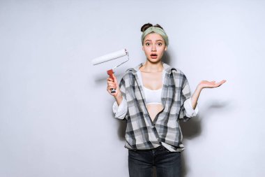 Daire tamir boyama duvarları için bir rulo tutan sürpriz genç kız