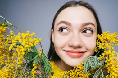 bahar hakkında düşünme kokulu sarı Mimoza, büyük bir buket tutan mutlu gülümseyen kız