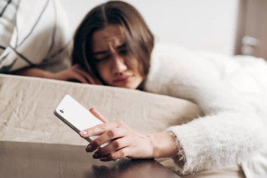 uykulu, memnun genç kız bir çalar saat sesi ile sabah erken, yalan yatakta uyandım