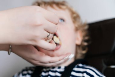 bakım genç bir anne küçük kıvırcık oğlu yararlı püresi ile beslemeleri bir aile Kahvaltı