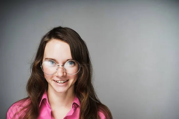 Bela trabalhador de escritório menina confiante em uma camisa rosa e óculos sorrindo e olhando para a câmera — Fotografia de Stock